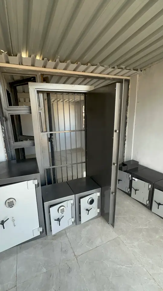 Steel grille security gate standing open beside Shellmate safes