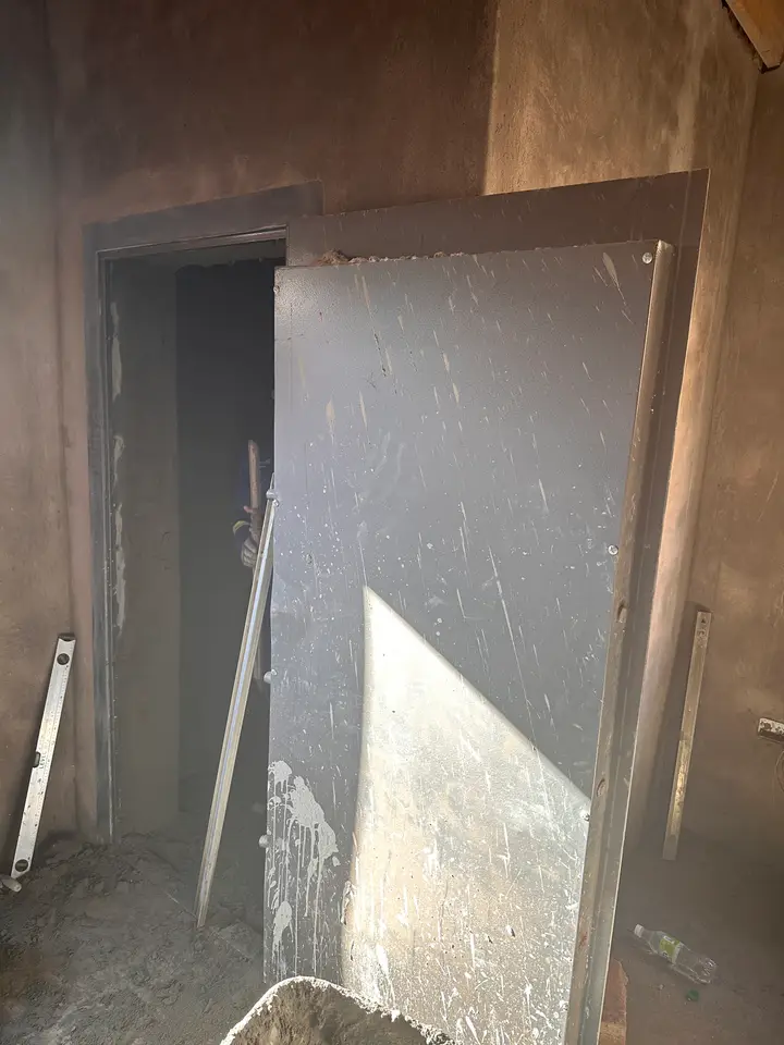 Shellmate strongroom door fitted into a brick wall, protective film still on the steel